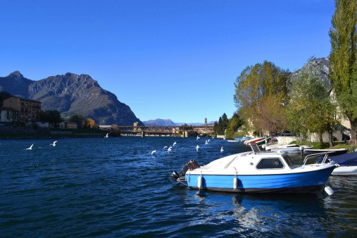 All-inclusive vacations- Motorboats anchored at Lecco and white seagulls flying.