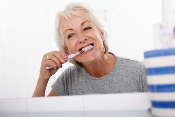 Senior woman brushing teeth